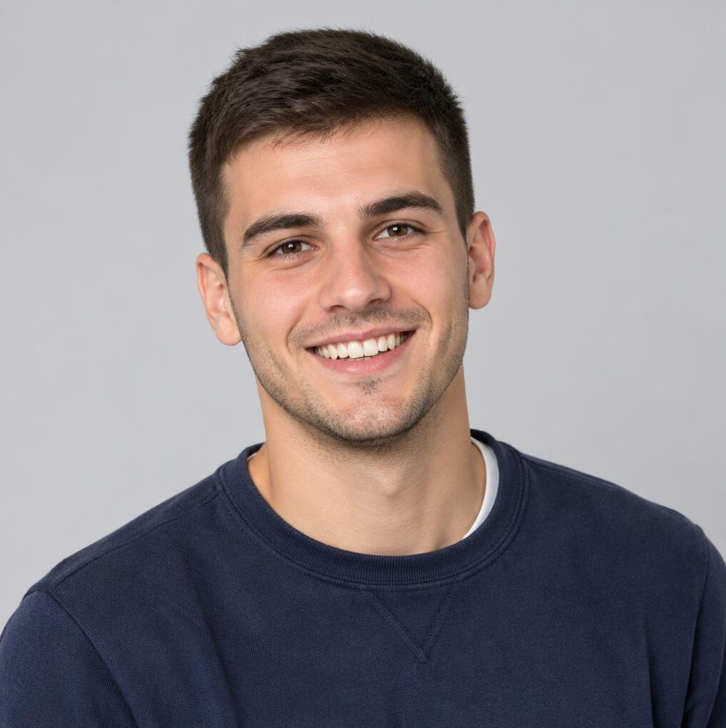Portrait of a young man smiling against a neutral background
